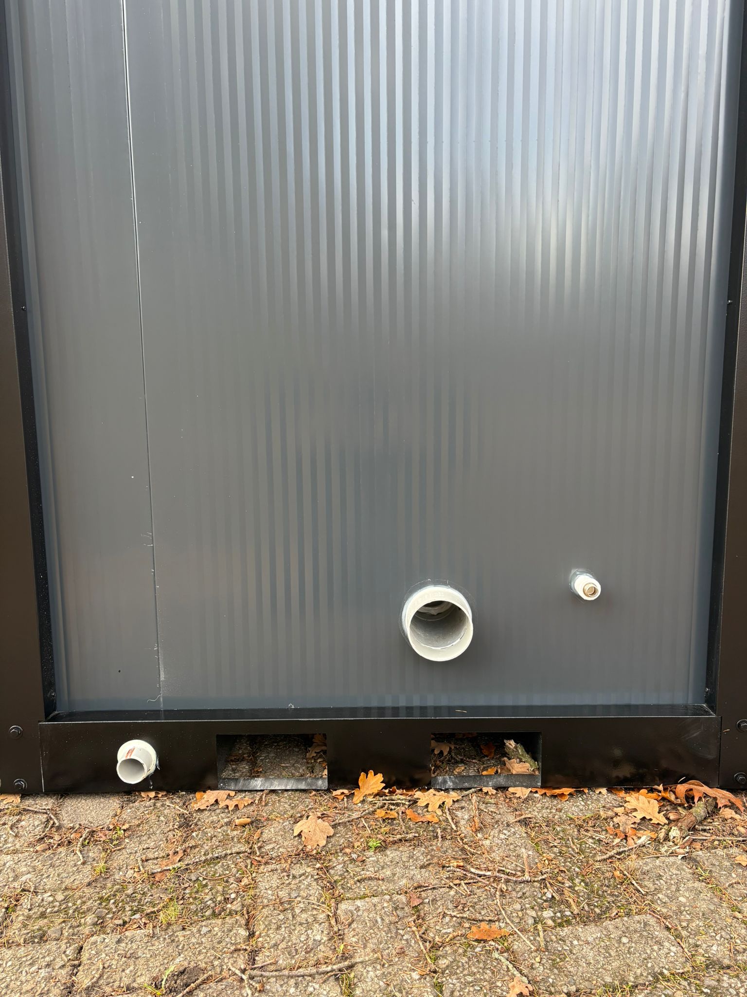 Aansluitingen en afvoeren achterzijde Achterzijde aansluitingen single toilet unit met urnoir