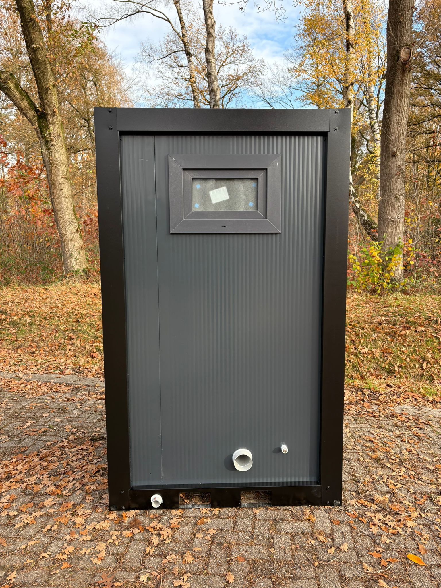 Achterzijde buitenkant 3 single toilet unit met urinoir achterzijde